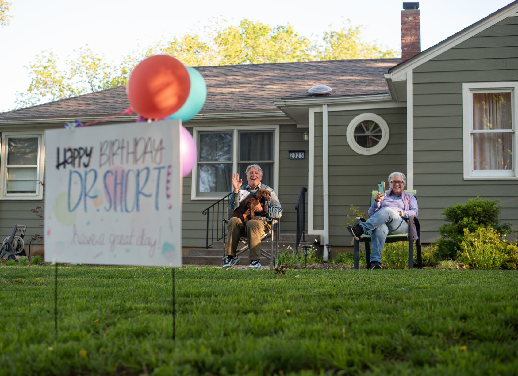 Dr. Steven Short and Whitney Short smile and wave as StevenÕs friends and neighbors drive by his home to wish him a happy birthday on Friday.
